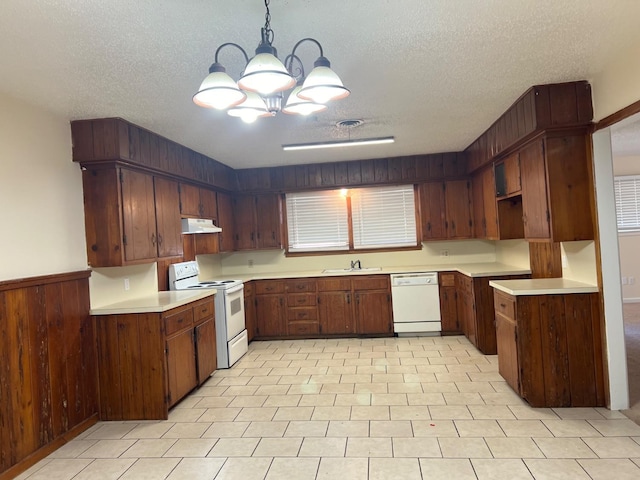 kitchen with hanging light fixtures, a textured ceiling, white appliances, and dark brown cabinetry