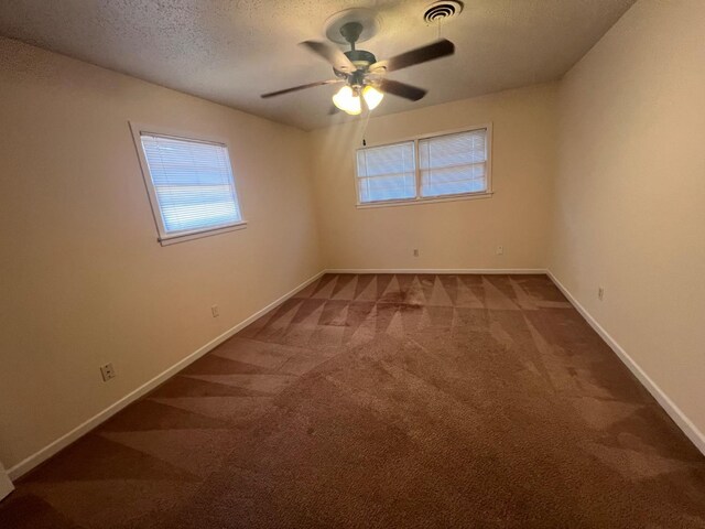 spare room featuring ceiling fan, carpet floors, and a textured ceiling