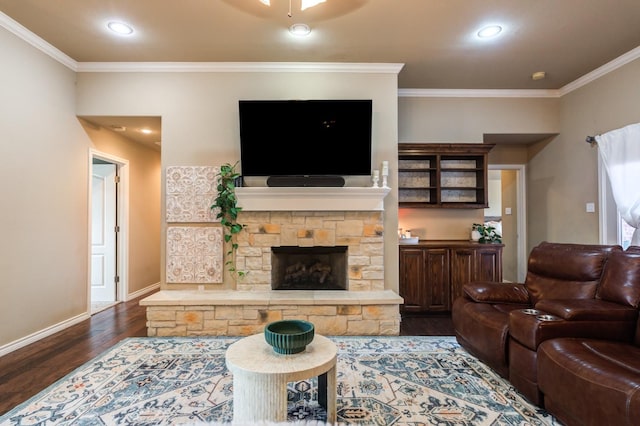 living room featuring crown molding, a stone fireplace, and dark wood-type flooring