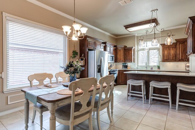 dining space with crown molding, a wealth of natural light, a chandelier, and light tile patterned flooring