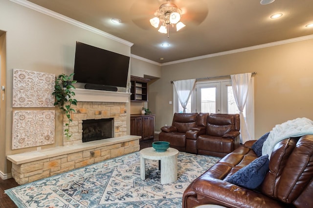 living room featuring a stone fireplace, ornamental molding, dark hardwood / wood-style floors, and ceiling fan