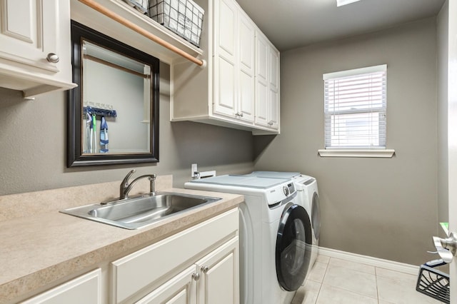 washroom with cabinets, washing machine and dryer, sink, and light tile patterned floors