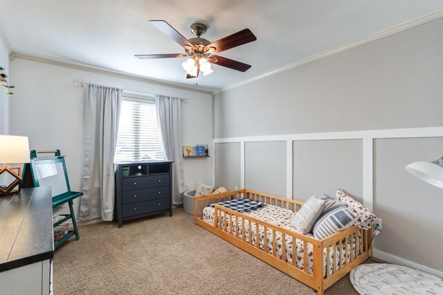 carpeted bedroom featuring ceiling fan and ornamental molding