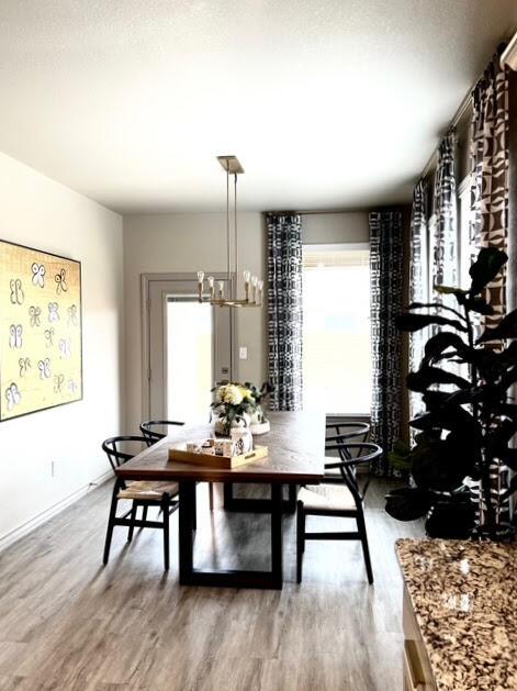 7101 22nd St, Lubbock, TX 79407 - dining space featuring wood finished floors, healthy amount of natural light, and a chandelier