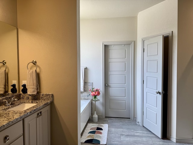 7101 22nd St, Lubbock, TX 79407 - bathroom featuring vanity, a garden tub, and wood finished floors