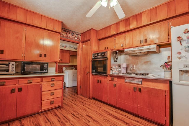 kitchen with ceiling fan, black appliances, a textured ceiling, washer / dryer, and light wood-type flooring