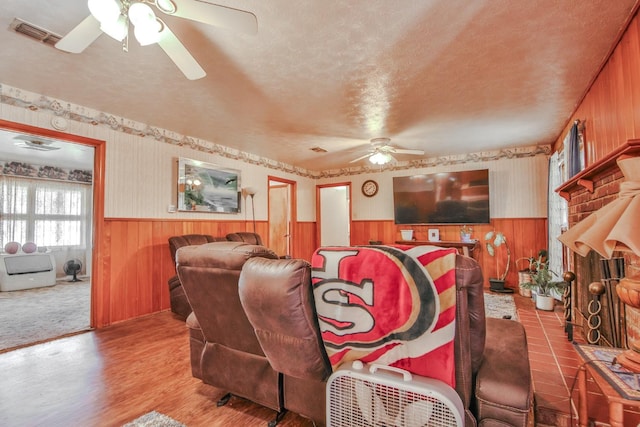 living room featuring ceiling fan, a textured ceiling, and light hardwood / wood-style flooring