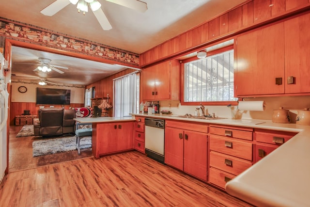 kitchen featuring white dishwasher, sink, kitchen peninsula, and light wood-type flooring