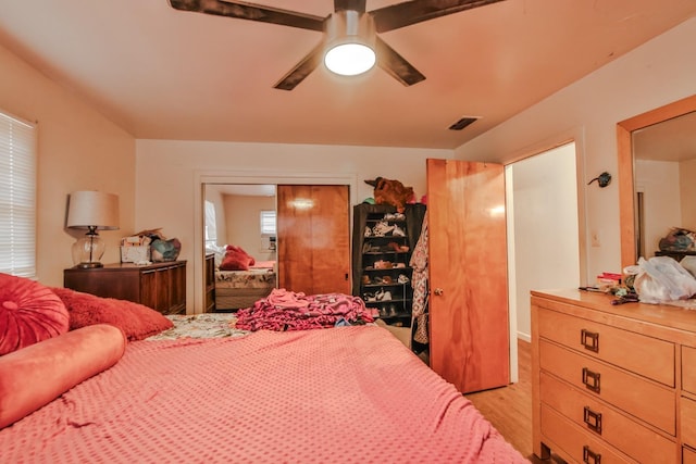 bedroom featuring ceiling fan, light hardwood / wood-style floors, and a closet