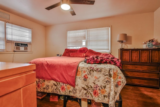 bedroom featuring dark wood-type flooring, cooling unit, and ceiling fan