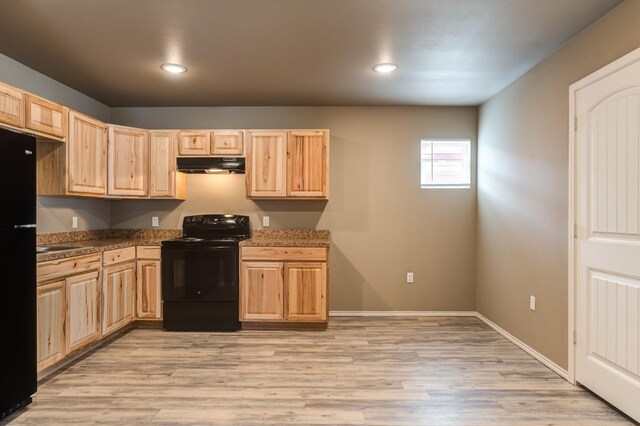 kitchen featuring light brown cabinetry, light wood-type flooring, and black appliances