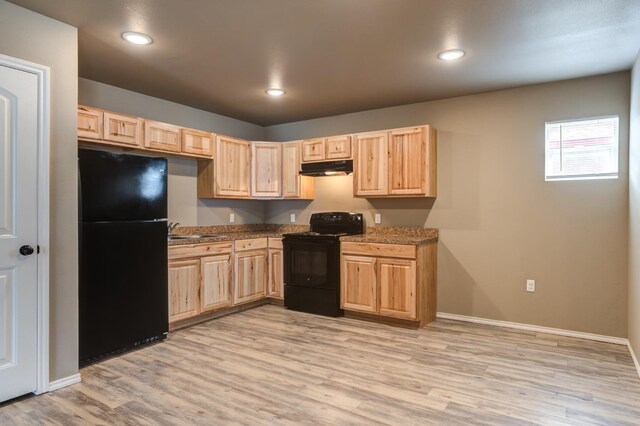 kitchen with light brown cabinetry, sink, and black appliances