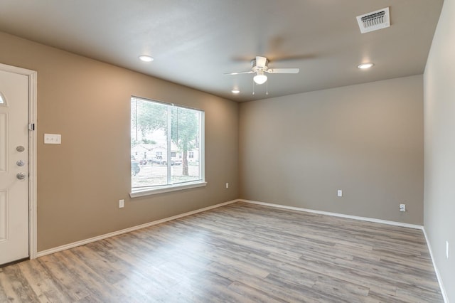 empty room with ceiling fan and light hardwood / wood-style flooring