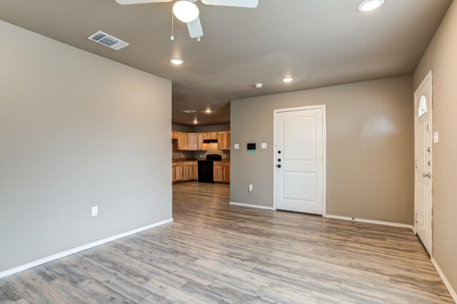 unfurnished living room featuring ceiling fan and light hardwood / wood-style flooring