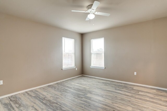 empty room with ceiling fan and light hardwood / wood-style flooring