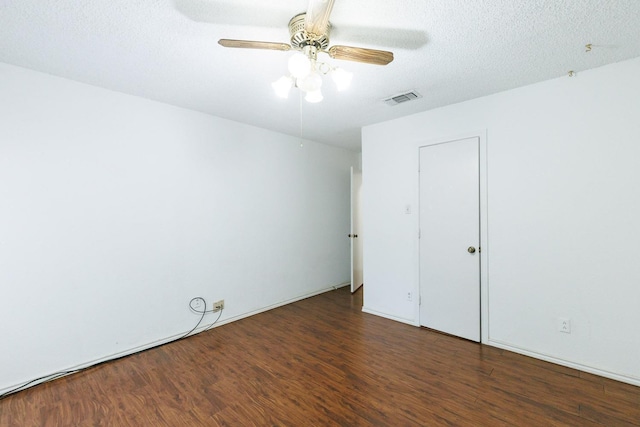 empty room with dark hardwood / wood-style flooring, ceiling fan, and a textured ceiling