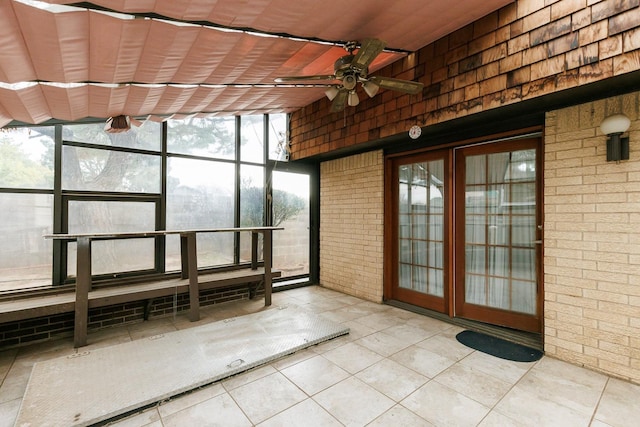 unfurnished sunroom with ceiling fan