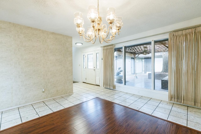 spare room with a wealth of natural light, a textured ceiling, and light wood-type flooring