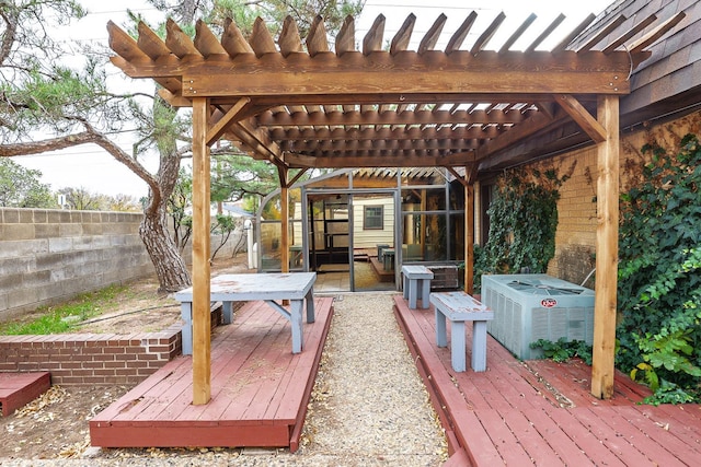 wooden deck featuring central AC unit and a pergola