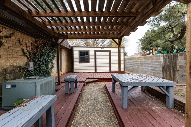 wooden terrace with central AC unit, a pergola, and a storage shed