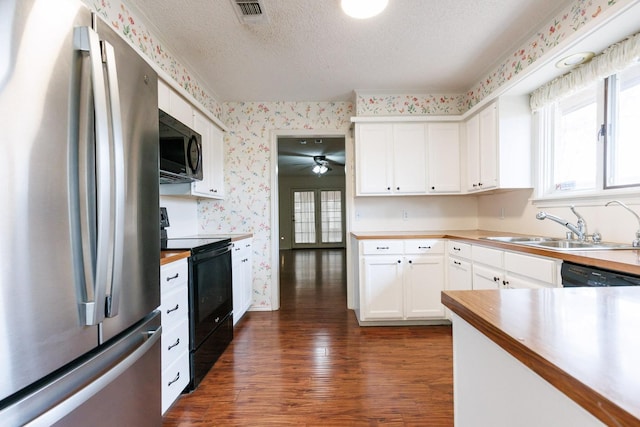 kitchen with dark hardwood / wood-style floors, white cabinetry, sink, black appliances, and a textured ceiling