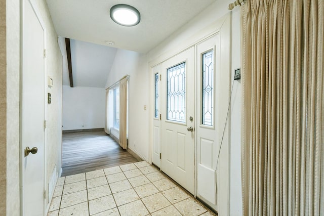 tiled entrance foyer with lofted ceiling