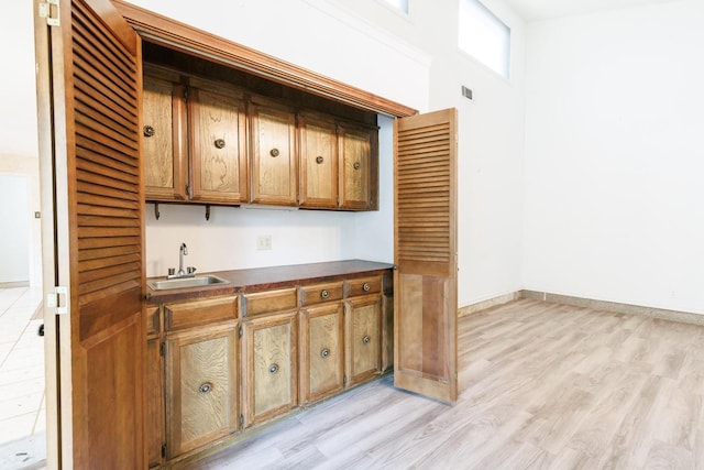 bar featuring sink and light hardwood / wood-style floors