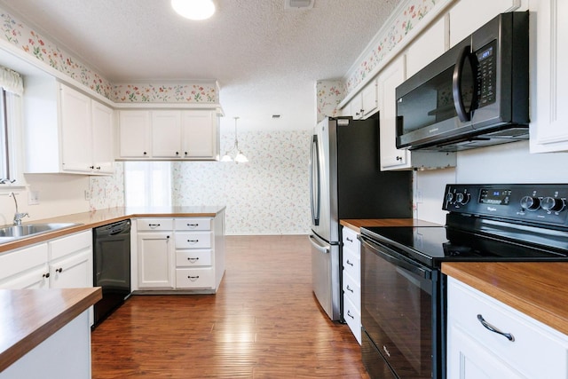 kitchen with pendant lighting, white cabinetry, a textured ceiling, and black appliances