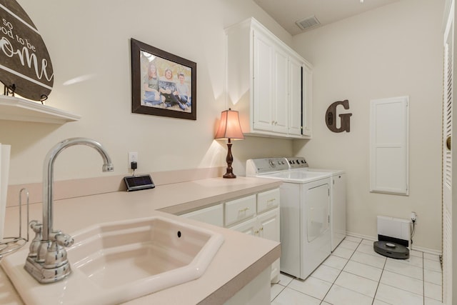 laundry area with visible vents, light tile patterned floors, a sink, independent washer and dryer, and cabinet space