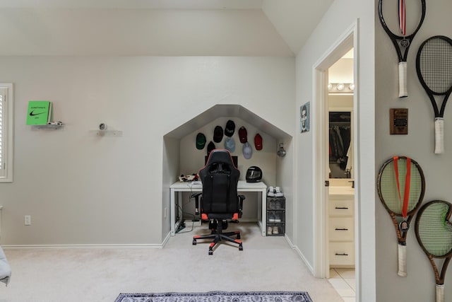 carpeted home office with vaulted ceiling and baseboards