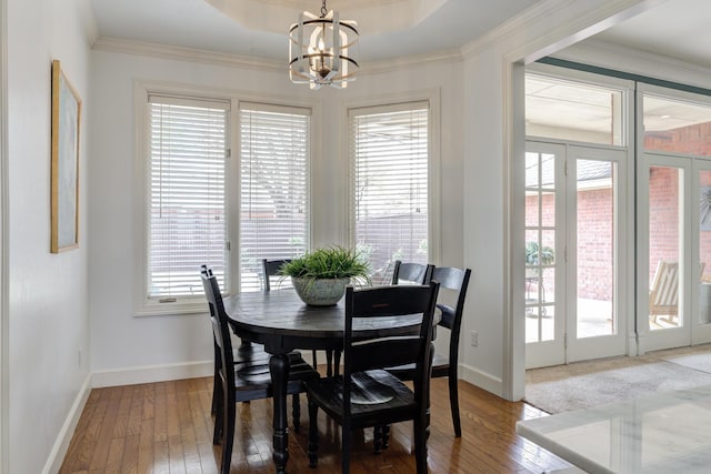 dining area featuring wood-type flooring, a wealth of natural light, baseboards, and a notable chandelier