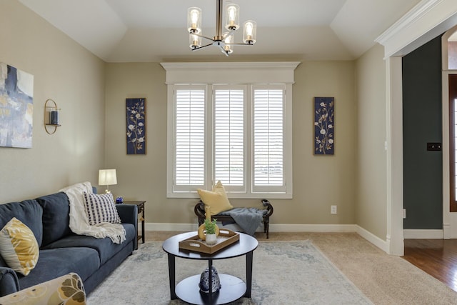 living room featuring baseboards, vaulted ceiling, and an inviting chandelier