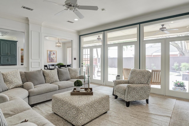living area with ceiling fan, light carpet, crown molding, and visible vents
