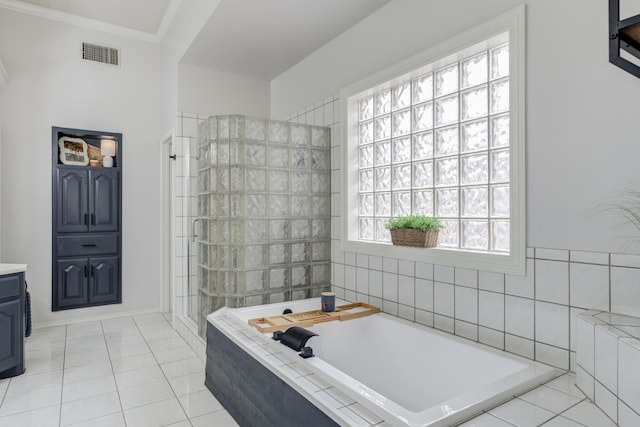 bathroom featuring tile patterned floors, visible vents, crown molding, walk in shower, and a garden tub