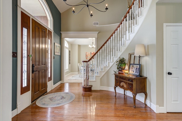 entryway with a chandelier, stairway, baseboards, and wood finished floors
