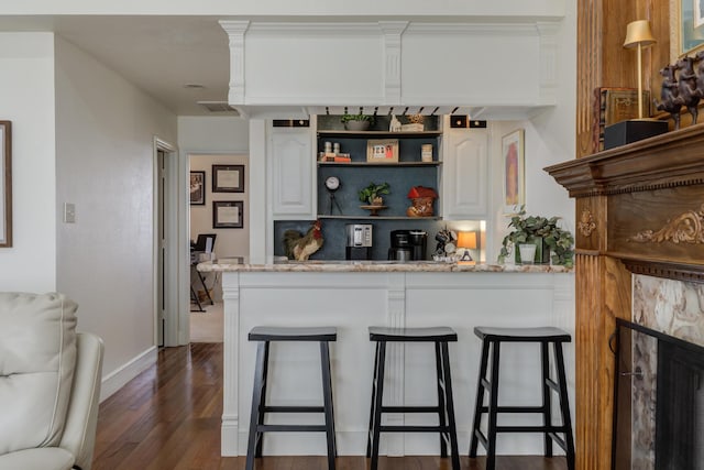 bar featuring wood finished floors, visible vents, and baseboards