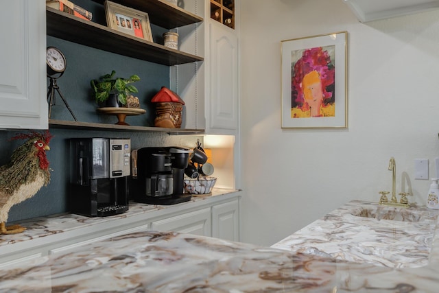 interior space featuring white cabinetry, open shelves, a sink, and light countertops