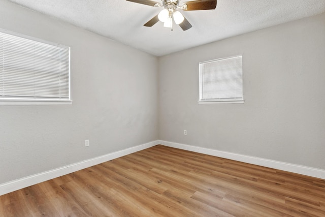 empty room featuring a ceiling fan, light wood-style flooring, and baseboards