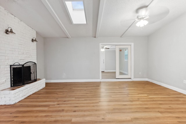 unfurnished living room featuring a fireplace, a ceiling fan, light wood-style flooring, and baseboards