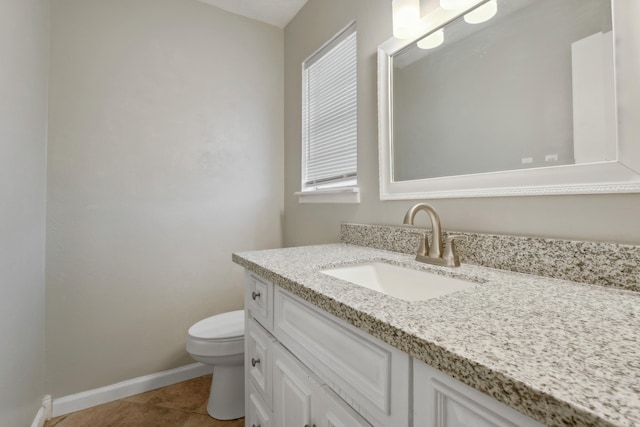 half bath featuring tile patterned floors, vanity, toilet, and baseboards