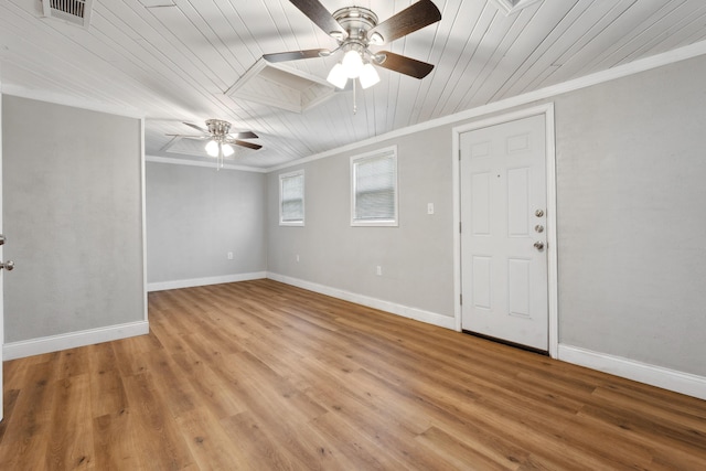 spare room featuring visible vents, ornamental molding, ceiling fan, and light wood-style floors