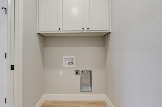 washroom with hookup for a washing machine, electric dryer hookup, cabinets, and light hardwood / wood-style floors