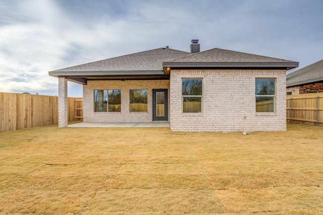 rear view of property featuring a patio area and a lawn