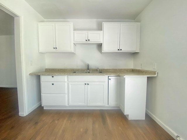 kitchen featuring sink, hardwood / wood-style flooring, and white cabinets