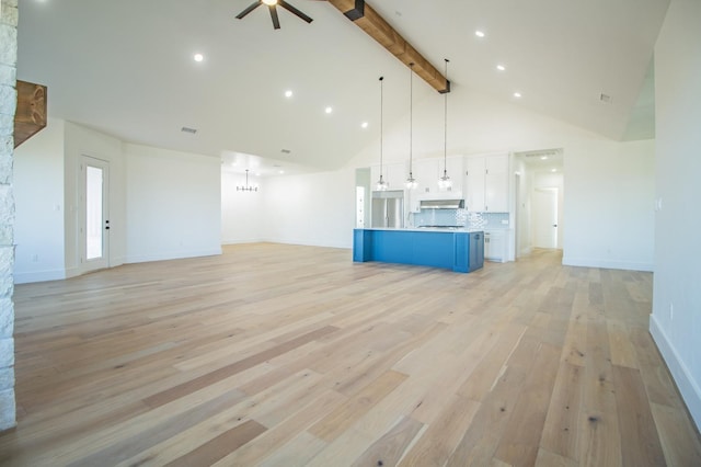 unfurnished living room featuring beam ceiling, light hardwood / wood-style flooring, high vaulted ceiling, and ceiling fan with notable chandelier