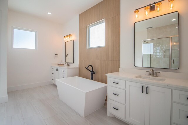 bathroom with vanity and shower with separate bathtub