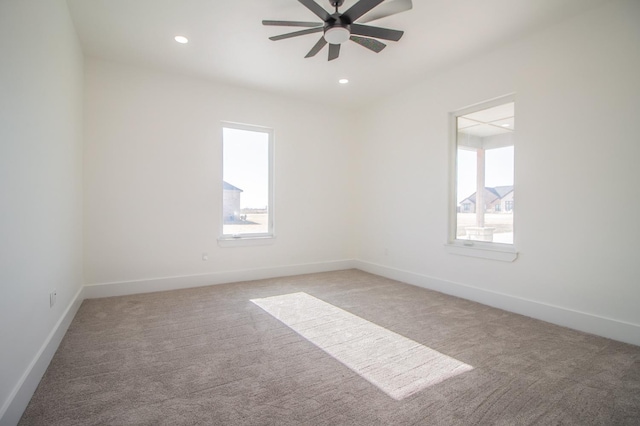 carpeted spare room with plenty of natural light and ceiling fan