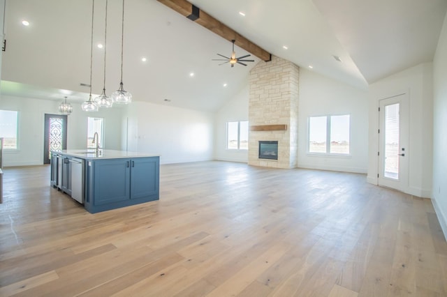 kitchen featuring sink, decorative light fixtures, an island with sink, and light hardwood / wood-style flooring