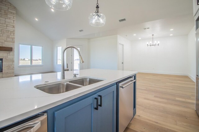 kitchen featuring sink, stainless steel dishwasher, and hanging light fixtures