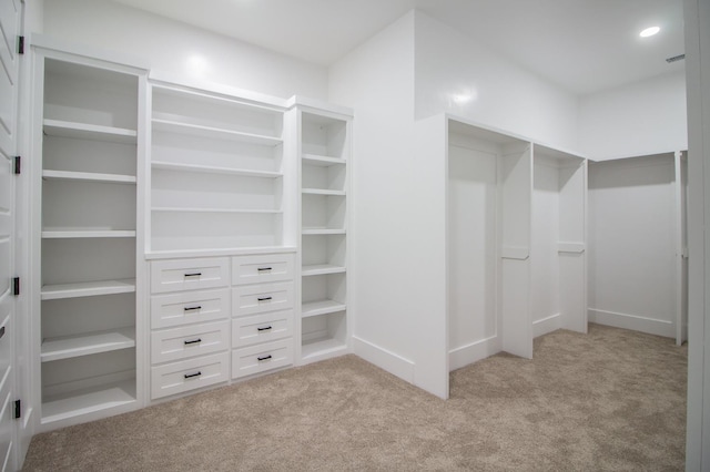 walk in closet featuring light carpet